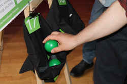 Teilnehmer legt Voting-Bälle in eine der Projekttaschen