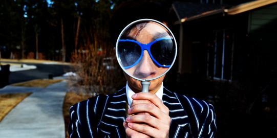 A person is holding a magnifying glass up to the eyes
