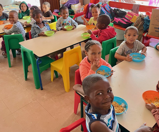 Children sitting at  tables and eating