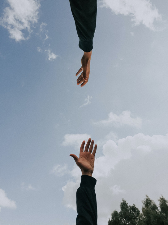 Two people reaching out their hands