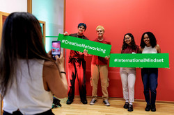 2026 #GlobalGallery Ein Foto wird von 4 Personen mit zwei Schildern gemacht