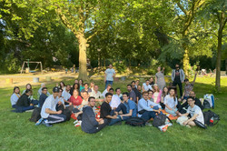 Eine große Gruppe von internationalen Studierenden macht ein Picknick auf einer Wiese im Westpark