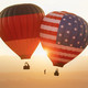 E_112021_Hasso-Plattner_cdn.evbuc.com_images_166610739.jpg 2 hot air balloons, one with the German flag and one with the US flag, float in the air