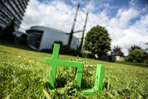 TU logo In the foreground one can see the green TU logo on the grass and in the background there is the Mathetower.