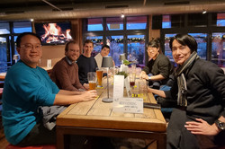 Menschen sitzen lächelnd an einem Tisch in einem Restaurant