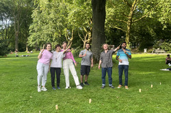 Das Bild zeigt eine Gruppe an internationalen Studierenden im Park, die Kubb spielen.