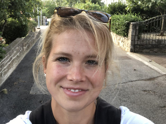 Erasmus_Dozentenmobilitaet_Vida-Mannl Eine blonde Frau mit Rucksack auf dem Rücken und Sonnenbrille auf dem Kopf macht ein Selfie