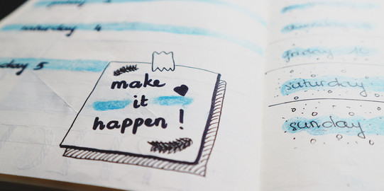 Symbolbild Planung Ein Planer mit dem Text "Make it happen"