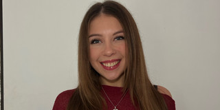 Eleonora-Worobiej Junge Frau mit rotem Oberteil lächelt in die Kamera