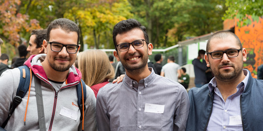 Come2Campus Drei Männer, die nebeneinander stehen und in die Kamera lächeln