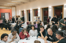 Teilnehmende des Sprachcafés sitzen an einem Tisch und spielen ein Kartenspiel.