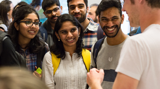 Come2Campus Lächelnde internationale Studierende, denen etwas erklärt wird.