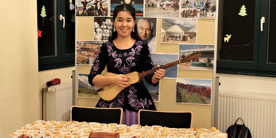 Internationales KulturCafé (IKC) Eine Gitarre spielende Asiatin beim Internationalen KulturCafé (IKC)