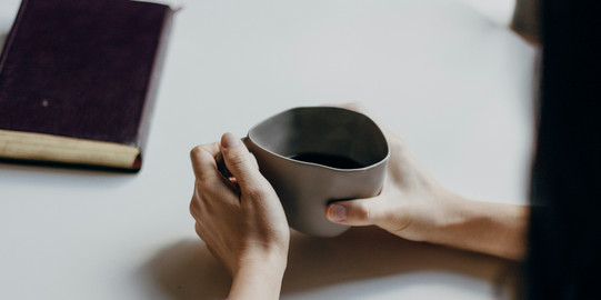 Two people at a table with a teacup