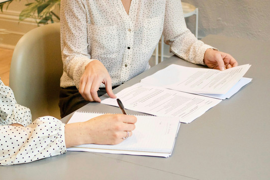 Bewerbungsworkshops: Bewerbungsunterlagen-Check Zwei Personen an einem Tisch. Vor Ihnen liegen Bewerbungsunterlangen.