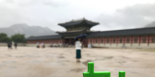 Traveling TU Korea Palast TU Logo vor einem koreanischen Palast