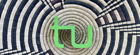 Makuleke Korb das TU Logo liegt auf einem Korb mit einem schwarz-braunen afrikanischenMuster