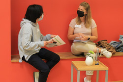 Tandem2Talking Mentee (rechts) im Gespräch mit Mentorin (links); beide sitzen auf Bank