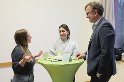 Tandem2Job Midterm Meeting 2023 Drei Personen stehen im Gespräch am Tisch