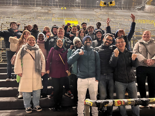 Menschen stehen jubelnd auf der Tribüne eines Fußballstadions