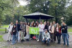 Sprachcafé_Fredenbaumpark Eine Gruppe von internationalen Studierenden steht vor einem kleinen Unterstand im Fredenbaumpark