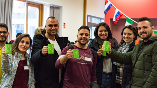 Come2Campus Eine Gruppe internationaler Studierender mit TU Dortmund Tassen in den Händen, blicken lächelnd zur Kamera