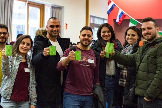 Come2Campus a group of international students with TU Dortmund University cups in their hands, smiling into the camera