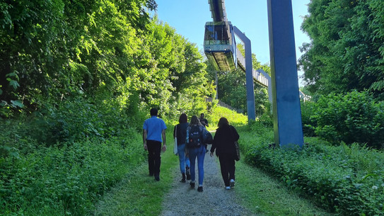People walking below the H-Bahn.
