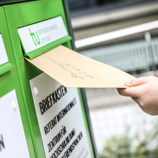 Fristenbriefkasten Eine Hand wirft einen Umschlag in den Fristenbriefkasten