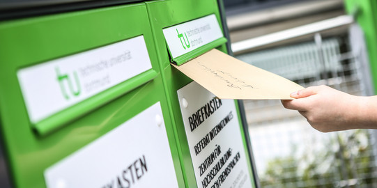 Fristenbriefkasten Eine Hand wirft einen Umschlag in den Fristenbriefkasten