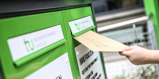 Fristenbriefkasten Eine Hand wirft einen Umschlag in den Fristenbriefkasten