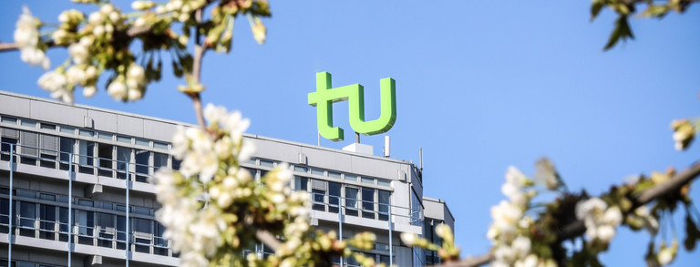 Kirschblüten vor dem Mathegebäude Kirschblüten und das Mathegebäude mit dem TU-Logo im Hintergrund.